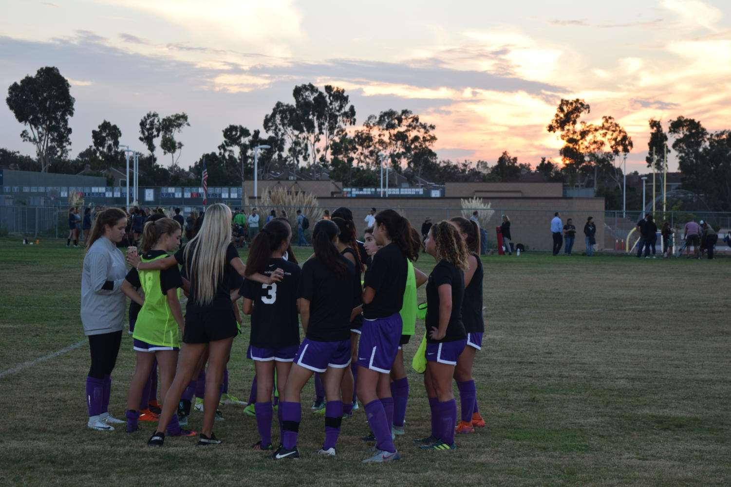 JV Girls' Soccer huddles before an evening matchup against University High.