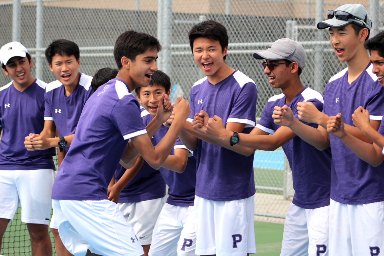 Sophomore Kameran Mody fist-bumps his team as he runs down the lineup at the start of the match in order to increase team spirit.
