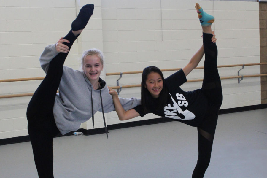 Freshmen Alina Medvedeva (left) and Nena Oshita (right) complete twin leg holds in the dance practice room. 