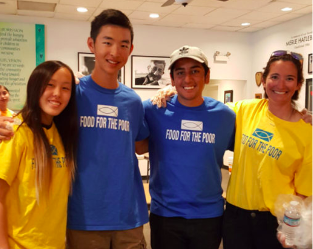 Sophomores Madelyn Noh, Justin Tam and Shawyan Rooein with world history teacher Natasha Schottland smile with their volunteer gloves in hand.