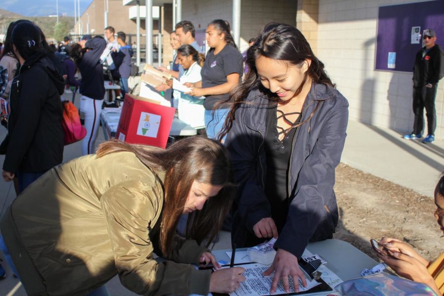 Sophomore Stephanie Tang helps an incoming freshman sign up for the National Organization of Women club. Students were able to watch performances from the visual and performing arts department and learn about the available activities on campus.