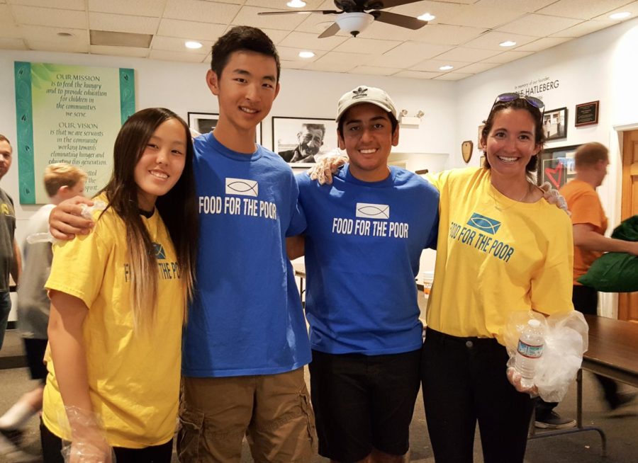 Sophomores Madelyn Noh, Justin Tam and Shawyan Rooein with world history teacher Natasha Schottland smile with their volunteer gloves in hand.
