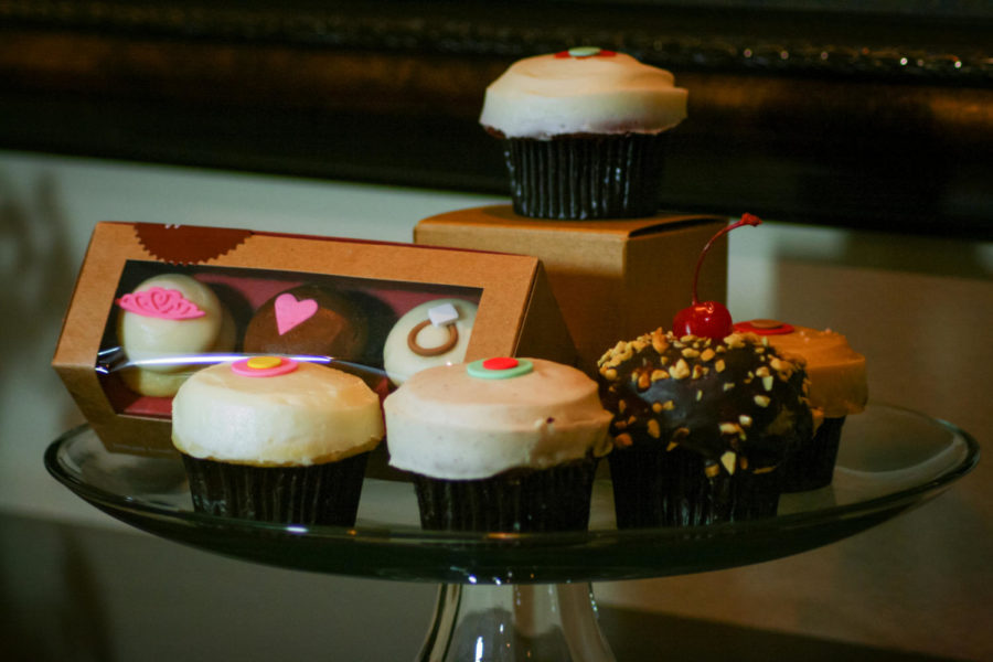 Displayed above from right to left are lemon, carrot, banana dark chocolate and salted caramel cupcakes. The original red velvet cupcake is shown on top. 