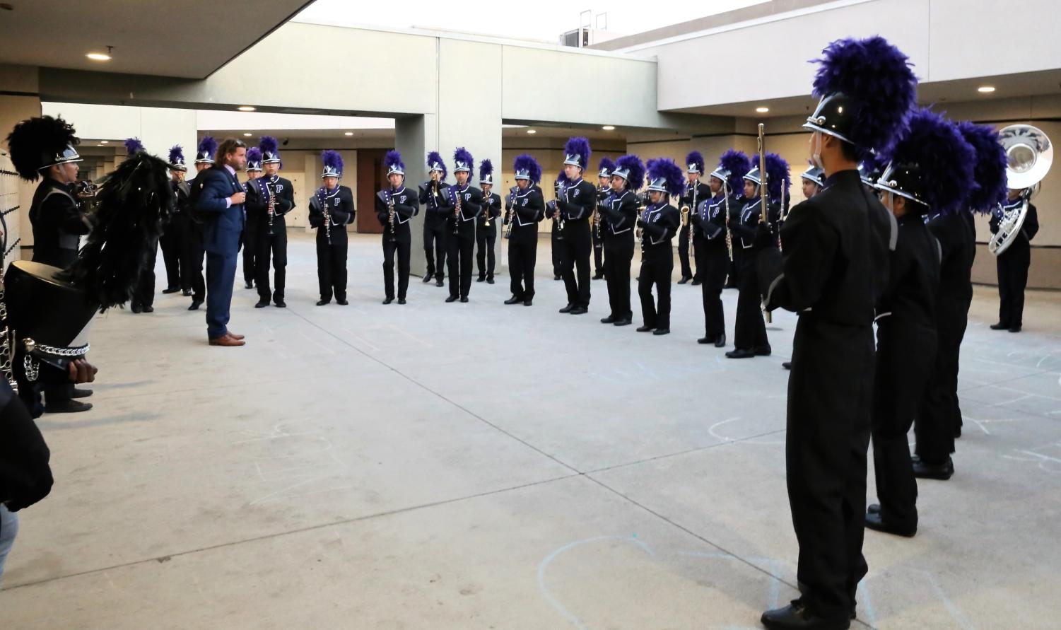 The marching band gets their final words of encouragement from teacher Desmond Stevens before embarking on their field show at the Tesoro Marching Band Field Tournament