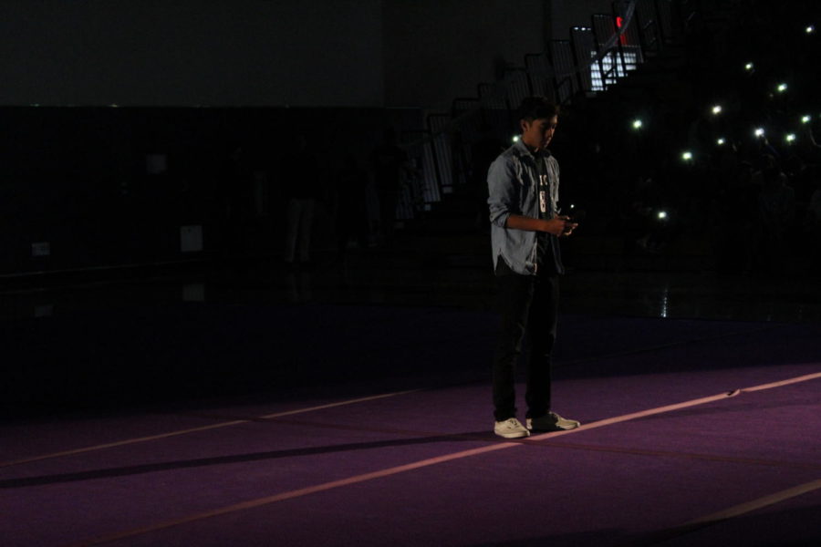 In the pitch-black gym, sophomore Ian Aros waits in the spotlight ready to hit the high notes of the national anthem.