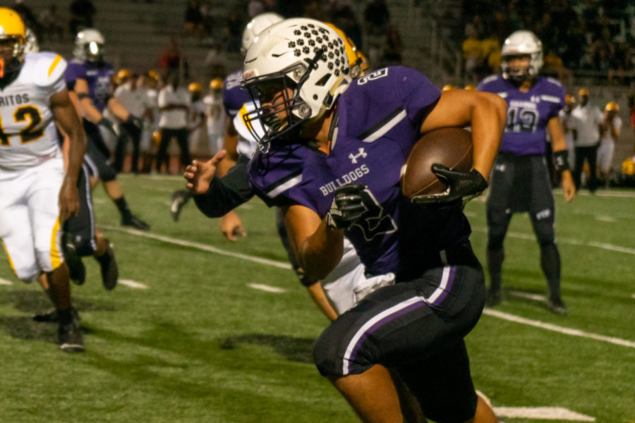 Running back and junior Trevor Yue receives a split pass by senior quarterback and co-captain Brandon Yue on the right wing to bypass Cerritos blockers. The Bulldogs are using a strategy, playing through the thirds, they practiced beforehand.