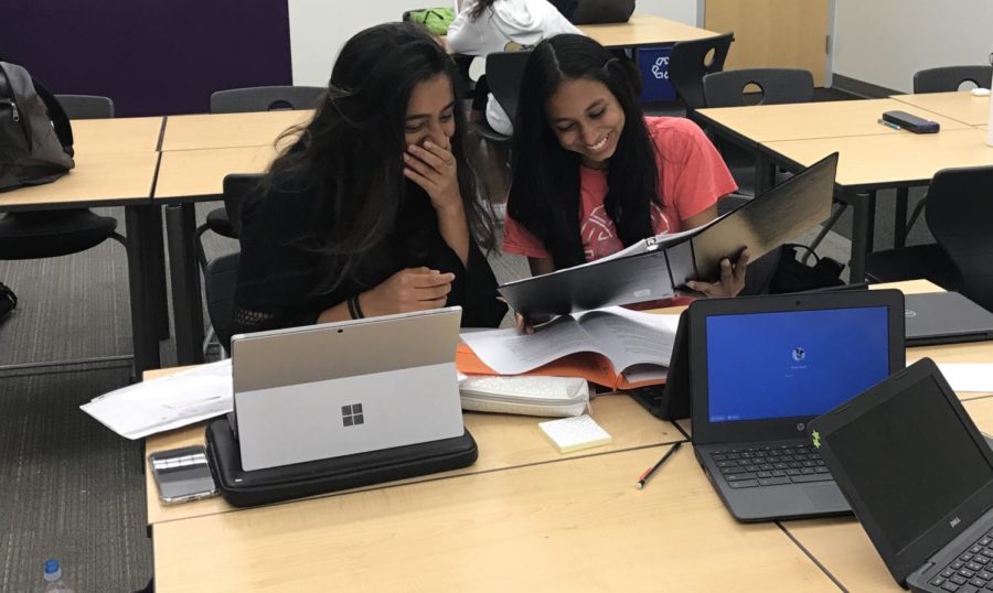 Junior Mahum Khan and sophomore Lavanya Gupta observe their case packets to try to come up with strategies which will enable them to create strong arguments.