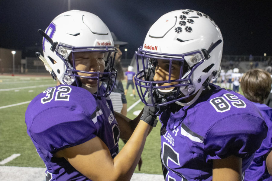 Juniors Dylan Chumm and Essa Khoso fix each other’s chin straps and 
tap helmets on the sidelines in preparation of yet another run out onto the field.
