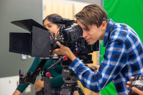 Sophomore Andrew Harriger looks through the camera to visualize and adjust his shot during the FilmEd summer camp. According to Ms. Murphy, the experience that the students gain using more expensive equipment enhances their abilities with the school equipment.
