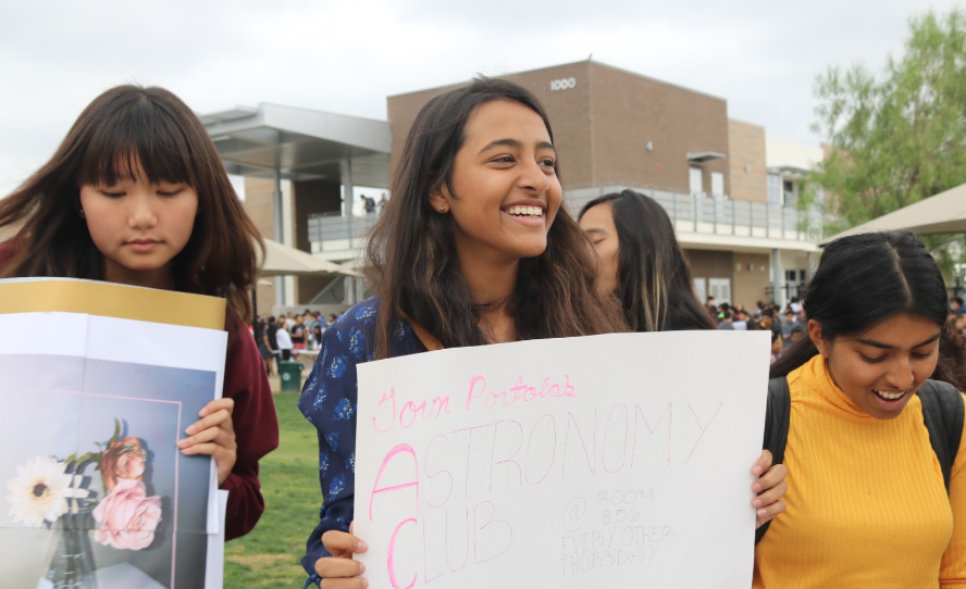 Sophomores Julianne Kim (left), Maham Khan (middle) and Mishtee Shaw (right) hold up  posters for the returning Biochemistry Club and the new Astronomy Club. 