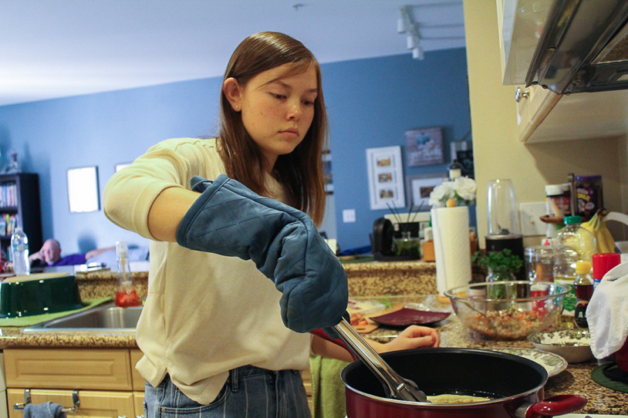 Junior Faith DeNeve prepares lumpia, a type of Filipino spring roll, from memory and shares her appreciation of the intimacy in home cooking as opposed to catering for large gatherings. The scratch-made variety yields a crisper exterior and the brightness of fresher ingredients. 
