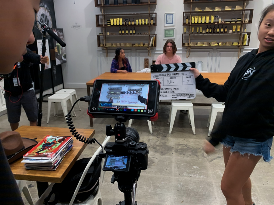 Producer and junior Skye Lee positions the clapperboard in front of the camera to designate the scene on the set of the short film, “Hello My Name Is.” “Hello My Name Is” is one of many entries from students being submitted to Orange County Film Festival this year. 
