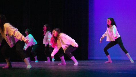 Dance 3 students crouch down during the solo section of the piece, “Crybaby,” choreographed by sophomore Mia Zappala. Choreographers were also responsible for costume design and stage lighting, fine-tuning these elements to enhance their overall performance. 
