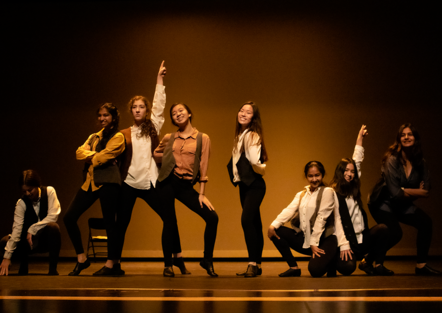  As “King of New York” from popular musical “Newsies” drew to a close, freshman Sophia Albornoz, sophomore Esha Ananth, junior Vina Dinh, sophomore Amanda Zhu, junior Saba Firouzabadi, junior Sonia Goyle, junior Chloe Le, junior Shideh Moayed and sophomore Megan Suhr pose for the crowd. The song choice influenced the costuming and prop choices.