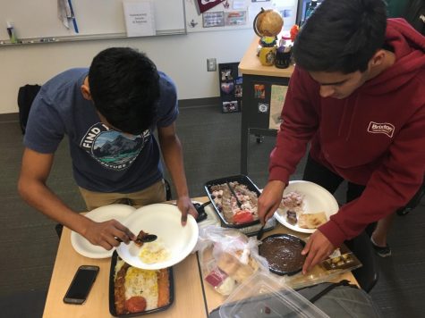 Club president and senior Kameran Mody and club member and senior Aditya Sasanur serve some Persian dishes. Made by speaker and senior Shawyan Rooein, he brought a chicken koobideh and a beef koobideh dish, which is composed of ground chicken/beef mixed with spices and onion and grilled on a skewer.
