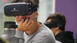 Senior Victor Loyola smiles as he explores different environments through the VR headset without leaving his seat. Among 8-to-17-year-olds who own virtual reality technology, 33% use the device for exploring environments, while 22% use it to learn something, according to a survey by Common Sense Media.