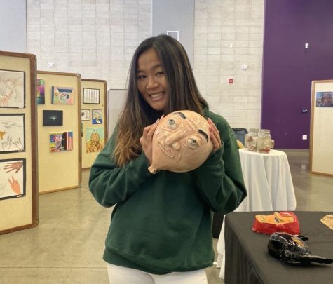 Junior Kayla Nguyen presents her ceramics creation of “Balloony,” inspired by the television show “Phineas and Ferb,” at Fine Arts Week.