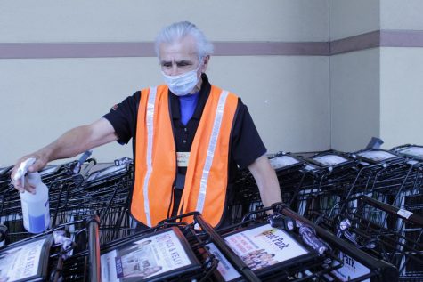 A Ralphs employee, Marko, sanitizes carts to ensure the safety of customers. While Ralphs still maintains its normal operating hours as they are necessary for providing residents food and day-to-day essentials, they have implemented precautions that reduce risk of customers contracting the virus.
