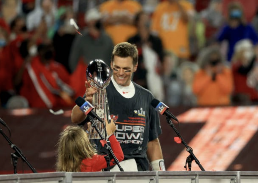 Tampa Bay Buccaneers quarterback Tom Brady and his daughter Vivian hold up the Vince Lombardi trophy as they celebrate the Buccaneers win over the Kansas City Chiefs in Super Bowl LV.
