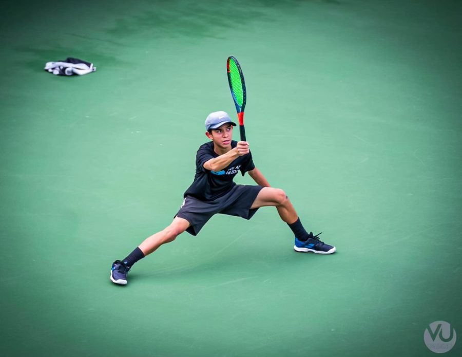 Junior+AJ+Moore+prepares+for+his+matches+during+his+warmups+by+hitting+forehand+shots%2C+as+well+as+practicing+his+backhand+shots%2C+volleys%2C+overheads+and+serves.+Moore%E2%80%99s+favorite+technique+is+his+between+the+leg+shot%2C+also+called+a+tweener.
