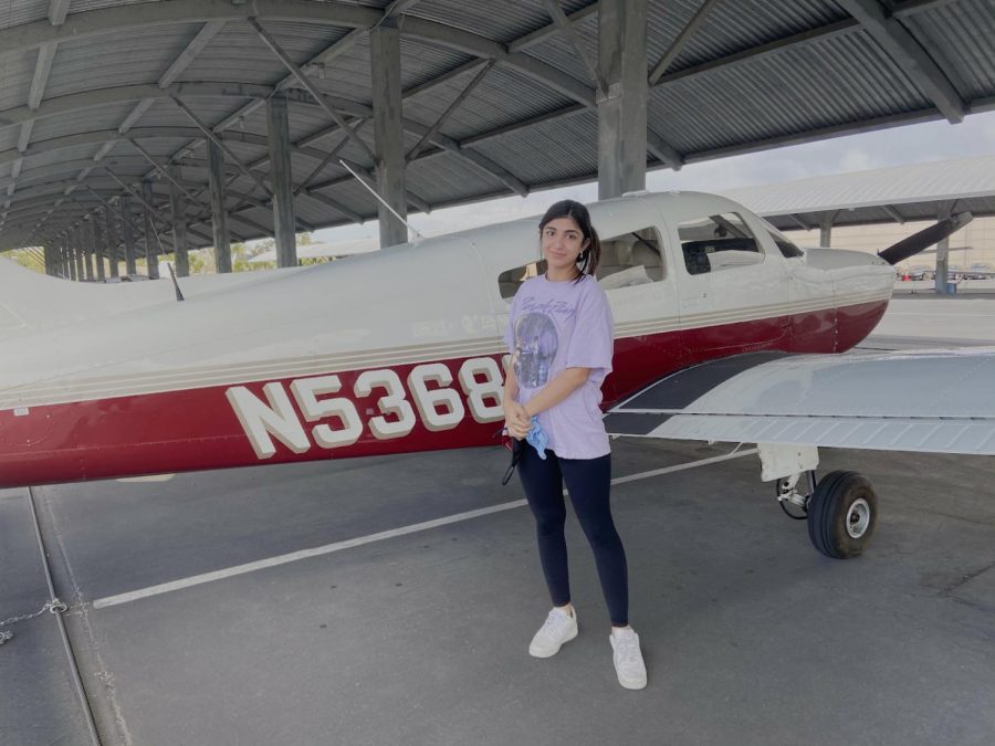 At John Wayne airport, sophomore Klara Parang stands next to the 2001 Challenger 605 after successfully navigating her first solo take-off on the runway.
