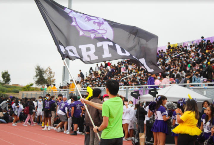 ASB vice president and junior David Kim waved the Portola flag before the start of the pep rally as students sat in their designated class sections. 