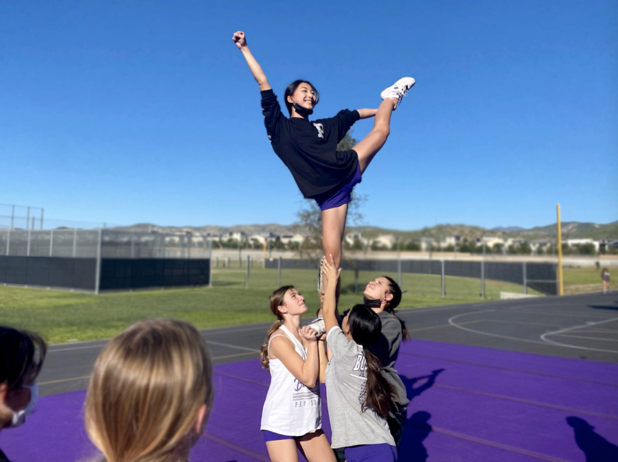 Flyer and freshman Hanna Kim hits a scale at a Portola High practice on Feb. 4. The preparation for the USA All Star Grand Championships involves a mix of performances at sports events – like basketball games – and independent competitive practices after school each day.
