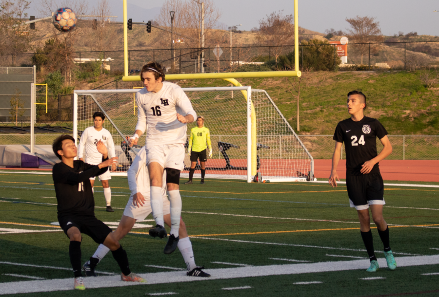Midfielder and sophomore Aaron Sato attempts to block the opponent after a throw-in from Laguna Hills High. 