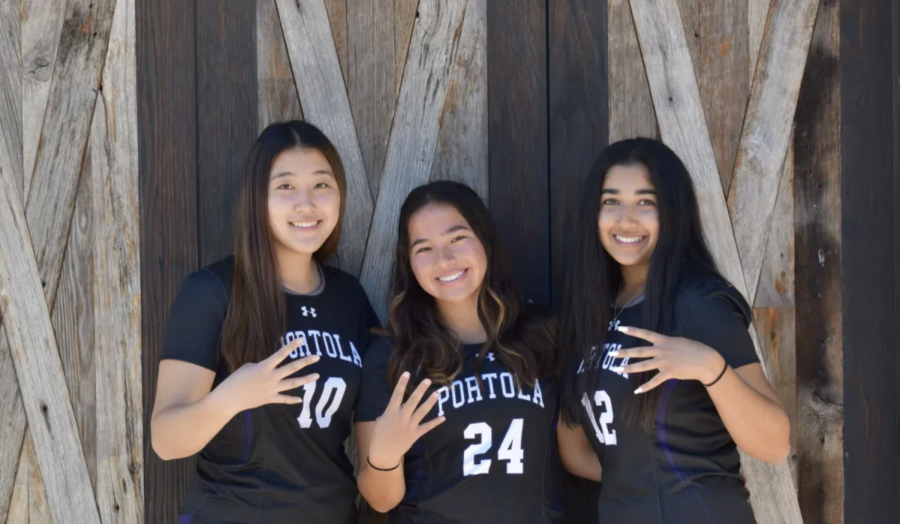 Girls’ lacrosse players and seniors Chloe Choi, Celine Aoki and Aafiyah Chohan hold up four fingers on their hands to symbolize their fourth year being on the girls’ lacrosse team. 
