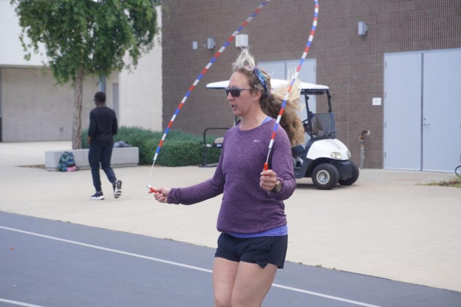 Physical education and health teacher Brittany Frymire walks her students through a jump-roping drill during class. According to Frymire, the most important part of her daily workouts is music, ranging from relaxing country music for longer running sessions to lively hip-hop on more intense weight lifting days.