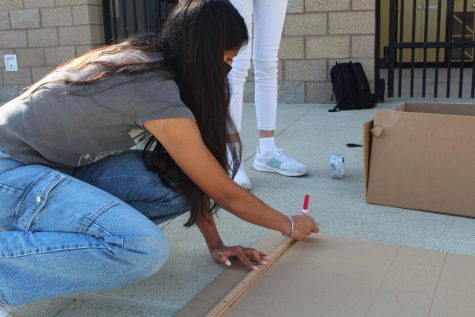 Junior Sarika Menon works on measuring out the length of her boat in preparation for the race. The size of the boat will be a crucial factor in determining which group will ultimately win the race, according to junior Sharon Chen.