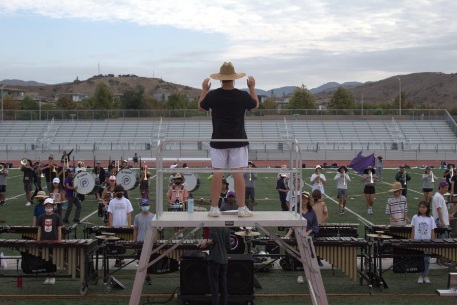 Drum major and senior Isaac Yoon leads the marching band during its morning practice. In addition to school practices, the production also makes sure to incorporate team bonding activities, such as writing and performing skits at band retreat.