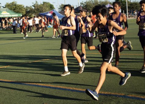 Boys’ frosh prepare to race before their cross country meet by running strides. Theirs’ is the first race of the night and looks of exhaustion and excitement are on their faces. 