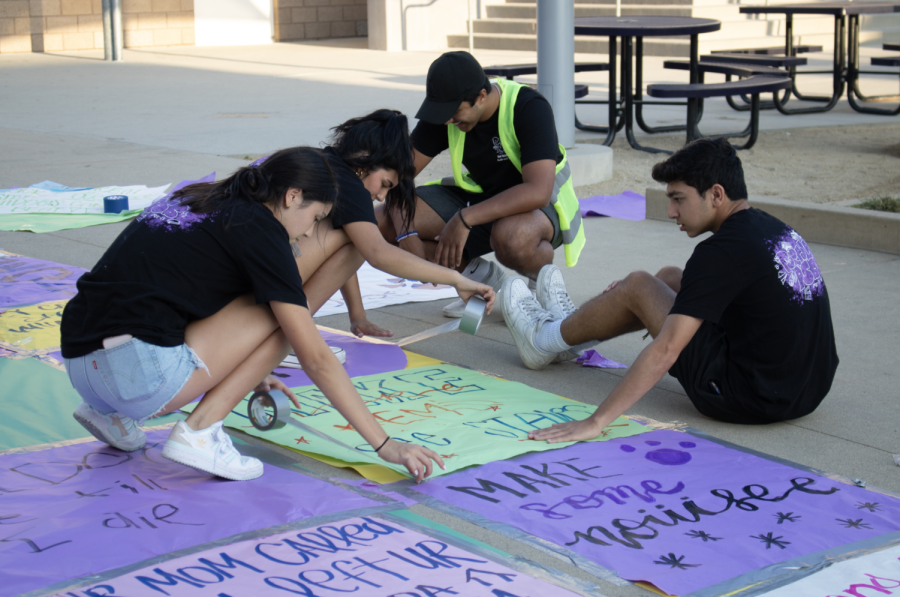 Seniors Rishabh Bajaj, Xasive Espinosa Aldave and Caroline Wang tape posters to the ground in celebration of Homecoming. Spirit Night was inspired by University High’s tradition, according to ASB co-adviser Kate Avery.
