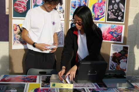 Junior Eric Liao and senior Nora Tang sort through the mini prints sold at Night of the Arts. As Visual Arts Board president, Tang was in charge of organizing the decorations and communicating with the board to choose the layout and music. “She communicates really well with all of us, and shes just a great person overall to work with,” vice president and senior Summer Hsieh said. “Shes good at making decisions that are great for the Visual Arts Board and takes care of the technical stuff such as making spreadsheets and copies.”
