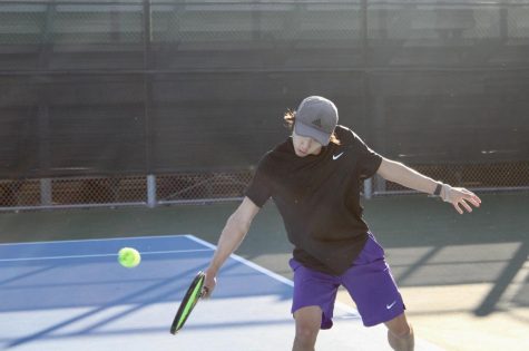 Sophomore Ethan Kim goes in for a one-handed backhand. Kim is in his second year of playing for boys tennis and is currently the teams best singles player, according to Pan.