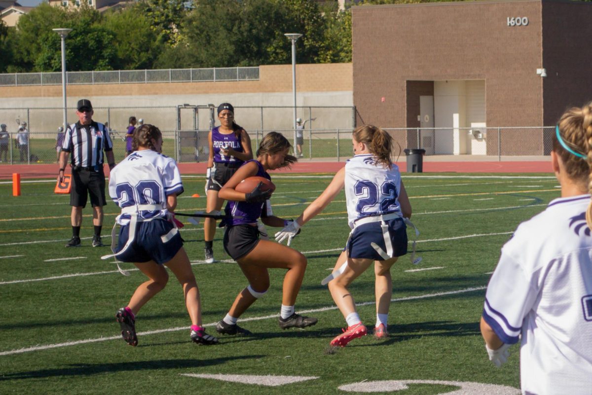 Wide receiver and sophomore Zoe Del Rosario attempts to evade two of Northwood High’s players as they try to pull her flag. To improve for future games, head flag football coach Julie Primero said that the team needs to work on their catching and communication with each other.