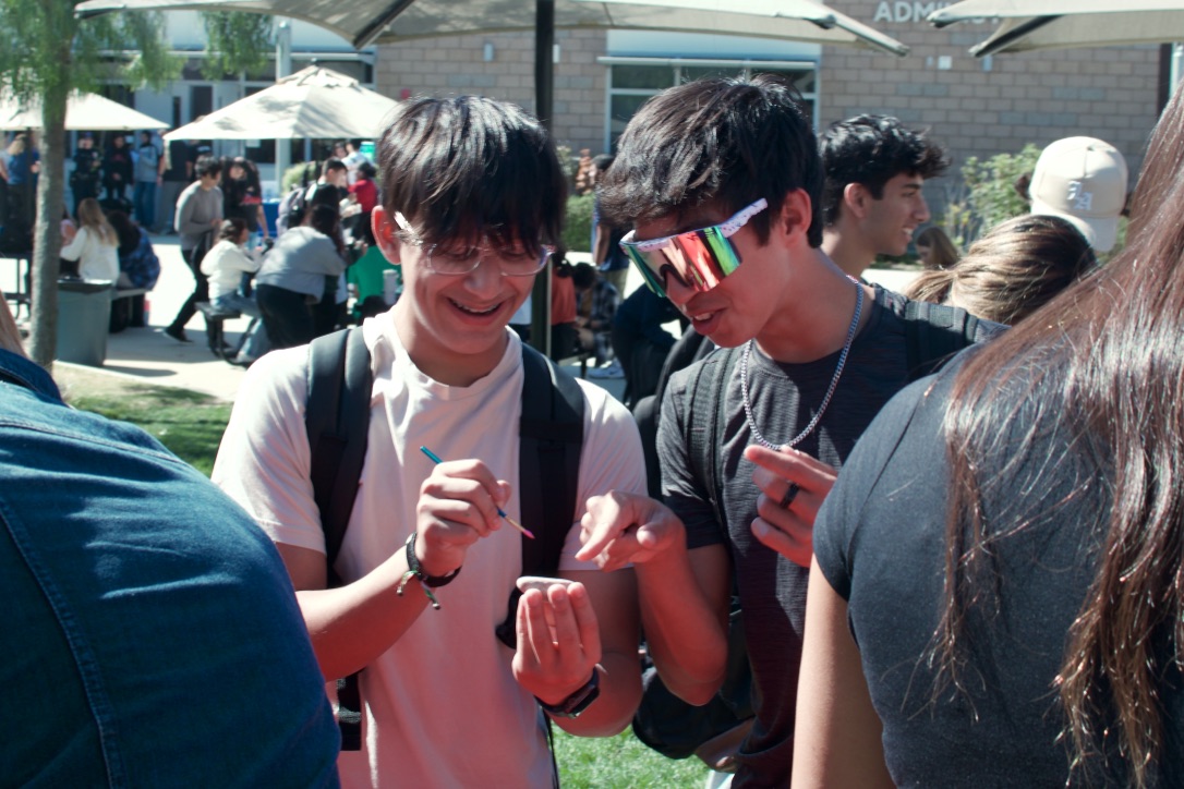 Freshmen Aman Talib and Paxton Shum paint rocks at Tuesday’s lunchtime activity set up by ASB. Students of all grade levels gathered in the quad to paint rocks with their friends. 