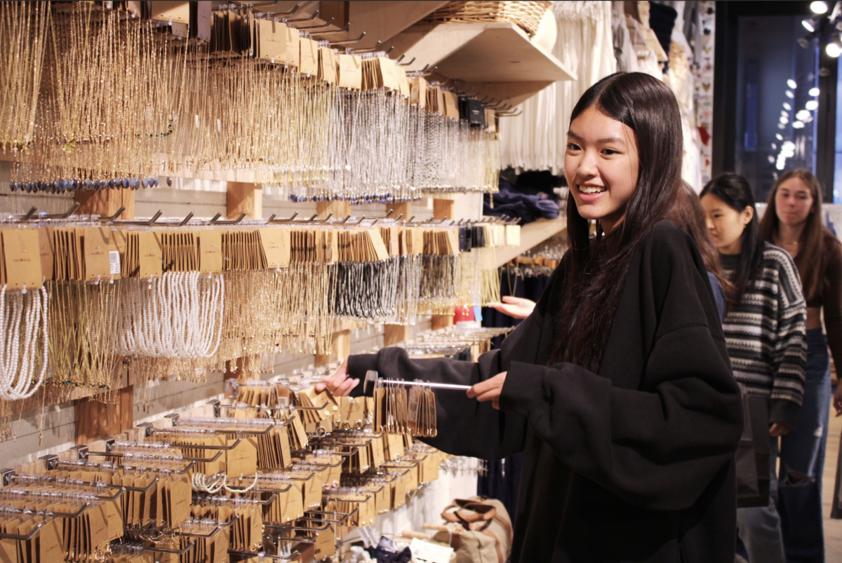 Senior Belan Ngo reorganizes necklaces in the accessory section at Brandy Melville. “I just got a promotion, and now Im the accessories manager, so basically I merchandise and market all the jewelry items, and Im in charge of making sure everything looks good,” Ngo said.