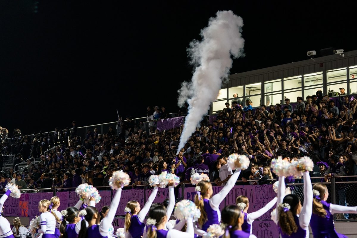 The stadium is packed with students for the Homecoming football game on Sept. 22. Junior Varsity Pep Squad cheers alongside Varsity, and ASB excites the crowd with smoke bombs for the special night. Chen said this is among her favorite photos from games at Portola High.