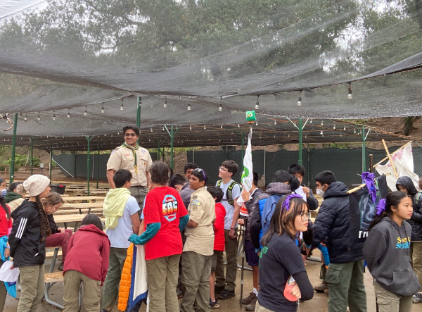 Senior and senior patrol leader Vish Satuloori stands on a lunch table to give his fellow scout members instructions for their upcoming volunteering activity.