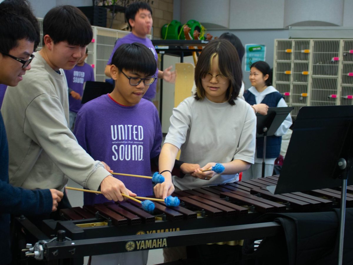 Sophomore Jenny Park, sophomore Darin Nguyen and sophomore Andrew Zhang guide mentee and sophomore Justin Mach’s mallets when playing the marimba, Mach’s favorite instrument to play, according to Mach. “The big piece in the beginning is just building that rapport and trust between the mentees and the mentors,” education specialist Melody Resendez said. “If we can get that going in a year, that alone, its a huge accomplishment.”