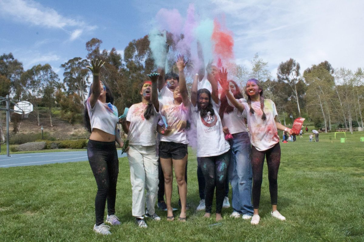 Portola High South Asian Student Association (SASA) board members throw up colored powder to commemorate the success of the event. “Portola has one of the largest attendance,” Sonthalia said. “Thats purely because of how big our club is as SASA and how many members we have. Im just so happy to see that Portola has so many people here that come together and are celebrating with us.”