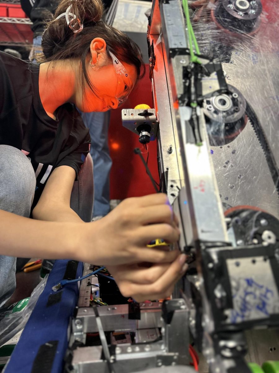 FIRST Robotics president and senior Amy Shok adjusts the robot created for the Orange County Robotics competition before a game. “We had to make sure that everything was going according to plan, and if there was any problem, we were prepared to fix it,” Shok said. “I think that problem-solving mindset was evident in our robot as well. Our robot had a lot of different changes made because the original design didnt account for things such as how the robot would be made.”
