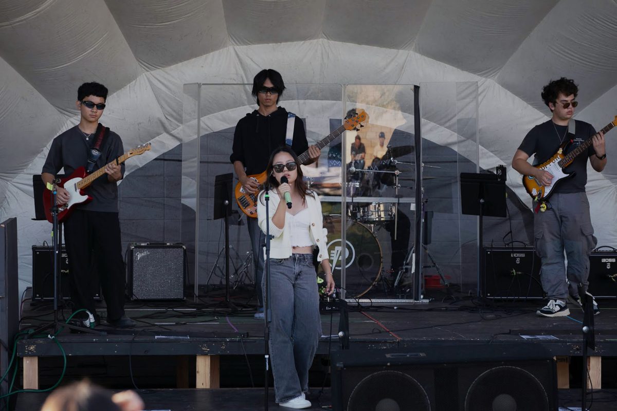 Vocalist of Crocs ‘N’ Socks and junior Suah Yang bundles up in a cardigan and black sunglasses for the cozy “Sweater Weather” by The Neighbourhood. “I’ve loved to sing since I was a little kid,” Yang said. “I’ve been doing choir for a long time, but last year Mr. Traska was like, ‘oh why don’t you do studio music,’ because I love to perform pop songs, and with a band. Performing it gives me joy because expressing my feelings through music is really fun.”
