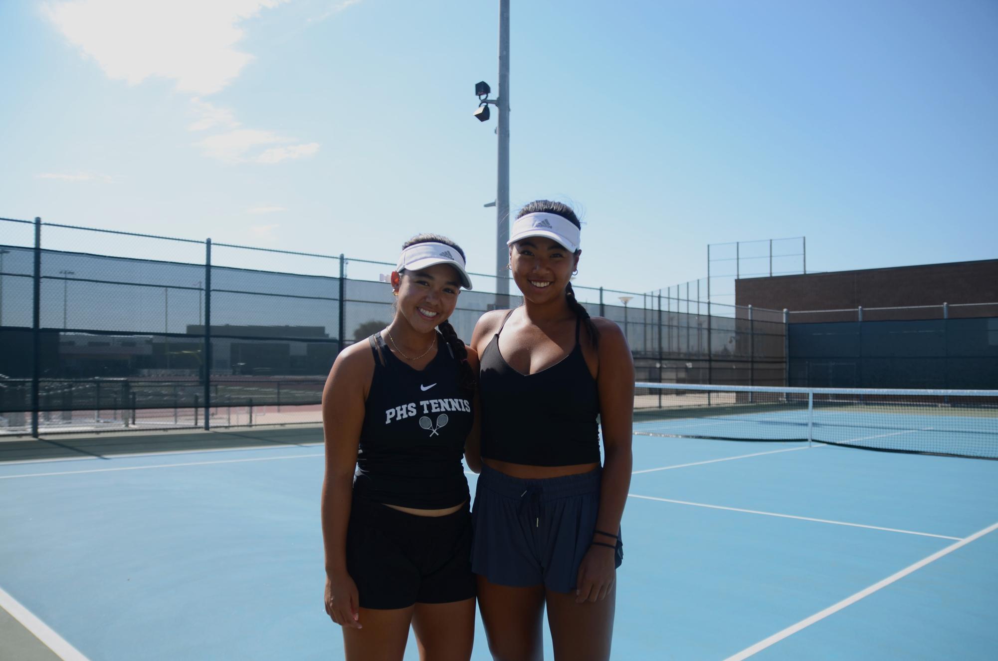 Leanna Roman and Kylie Nguyen prepare for their Oct. 2 practice after school. They interact with the entire team before even the warm-ups begin. “We’re on the court as a family,” according to Roman.