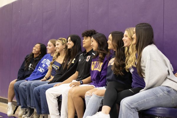 All nine committed athletes smile for a photo just before the ceremony begins. The ceremony took place on Nov. 15 in the gym during office hours. Each athlete typically invites a coach or teacher to give a brief speech about their academic and athletic accomplishments, but because the number of signees this year was so much greater than years past, athletes were simply announced by name, the school they will be attending and the athletic program they have committed to, according to assistant athletic director Brian Smith.
