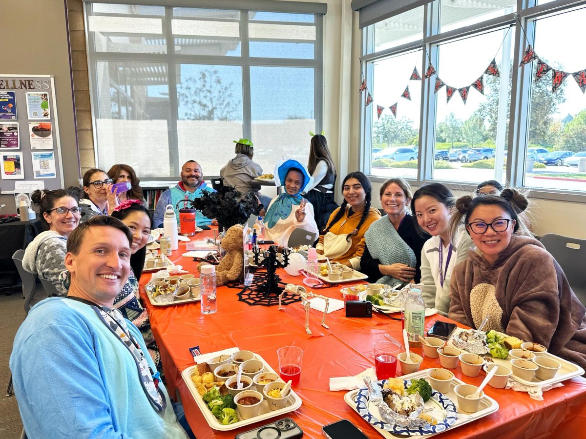 Dressed up as babies, the counseling department poses for a picture at their table beside their plates of food, ready to enjoy their chili and sides of cornbread and stuffed potatoes. 
