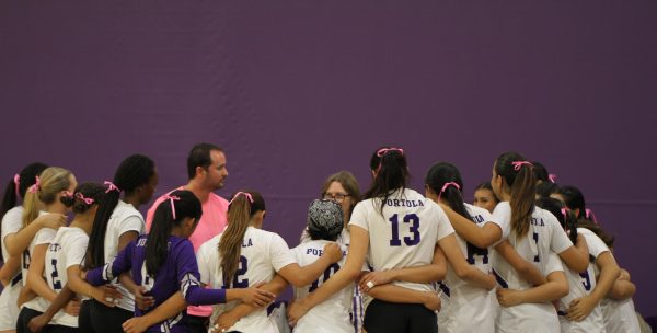 Girls’ volleyball huddle together during their pink out game for breast cancer awareness on Oct. 10. “Sports can act as a network,” head coach and social studies teacher Martasian said. “Sports can at least offer support and communication, like how to draw awareness about some of these things that are much greater and much more important than sports themselves.”