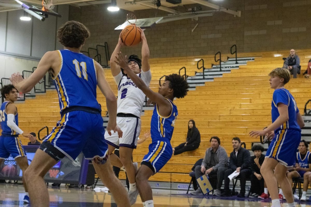 Point guard and junior Lucas Ip fights to score a basket between two defenders. “I think one of our strengths is shooting,” Ip said. “We have a lot of good 3-point shooters, and then we have a lot of players that are able to drive and facilitate the offense, which allows us to get these 3-pointers.”